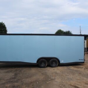Side view of a light blue enclosed cargo trailer with black trim and tandem wheels, branded "Pro Series," parked on a dirt lot among other trailers under a cloudy sky.